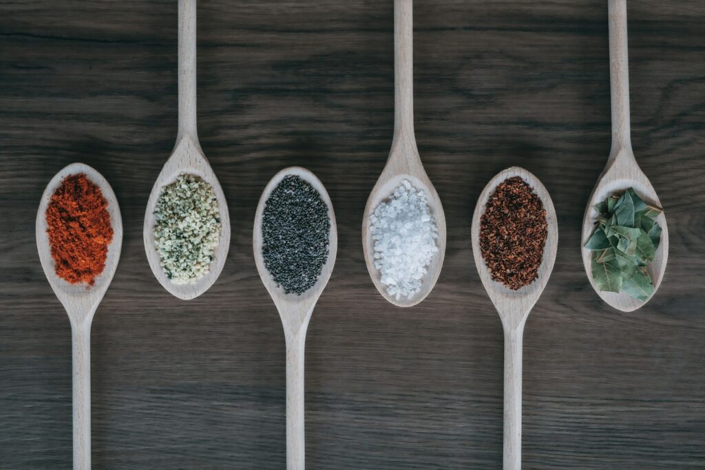 assorted-color spoons with spices