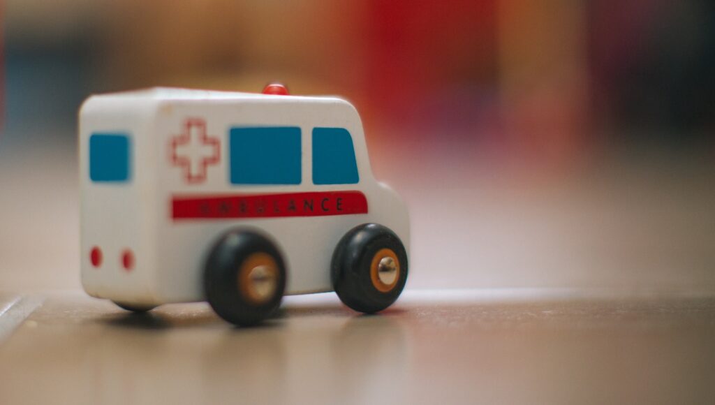 a toy ambulance is sitting on the floor